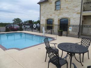 a patio with a table and chairs next to a pool at Black Gold Inn in Yoakum