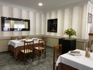 jadalnia ze stołami i krzesłami w restauracji w obiekcie Hotel Casa Portuguesa w mieście Meaño