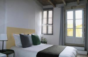 a bedroom with a bed and a large window at In Situ B&B in Uzès