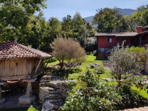 un jardín con una casa y un patio con árboles en Amaicha Apartamentos Rurales en Ribadesella
