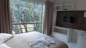 a bedroom with a bed and a large window at Flat Beira Rio in Ribeira