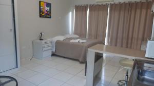 Dormitorio pequeño con cama y mesa en Flat Beira Rio en 