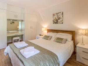 une chambre avec un grand lit avec deux serviettes dessus dans l'établissement Gardener's Cottage, à Belford