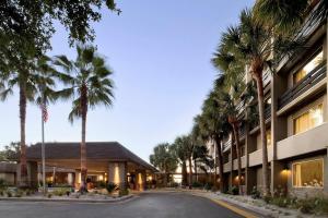 a building with palm trees in front of a street at Beach House Resort Hilton Head Island in Hilton Head Island