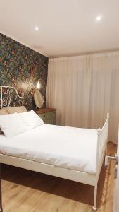 1 cama blanca en un dormitorio con pared en T2P Pilar House, en Vila Nova de Gaia