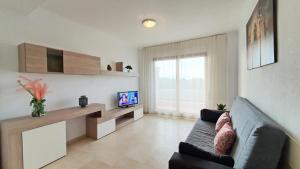 a living room with a couch and a tv at SALINAS GANDIA - Solo alquiler Familias in Gandía