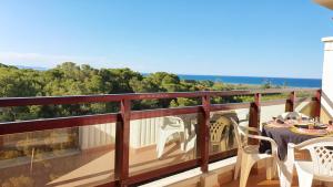 a balcony with a table and chairs and the ocean at SALINAS GANDIA - Solo alquiler Familias in Gandía