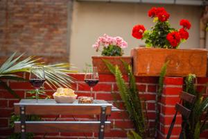 a table with two glasses of wine and flowers at Taormina Apartments in Taormina