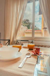 a table with a plate of food and a window at Taormina Apartments in Taormina