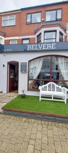 a white bench sitting in front of a store at the belvere in Blackpool