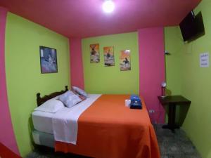 a bedroom with a bed with green and pink walls at Hotel Casa Del Viajero in Quetzaltenango +67 photos