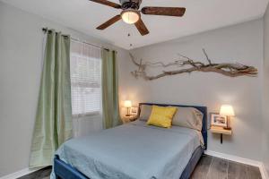 een slaapkamer met een bed en een plafondventilator bij Driftwood Castle Urban Oasis with Firepit near Convention Center and Amalie Arena, Room for 6 in Tampa