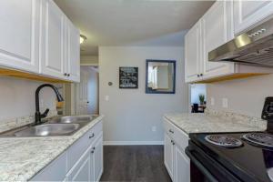 een keuken met witte kasten en een spoelbak bij Driftwood Castle Urban Oasis with Firepit near Convention Center and Amalie Arena, Room for 6 in Tampa +8 foto's