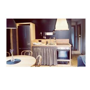 a kitchen with a table and a sink and a table and chairs at Apartamentos Las Agüeras in Linares