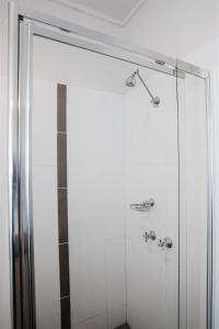 a shower with a glass door in a bathroom at Hurley's Bar & Bistro in Kyabram