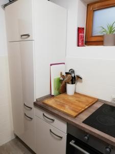 a kitchen with a wooden cutting board on a counter at Ferienwohnung Nagelfluh Allgäu in Oberreute