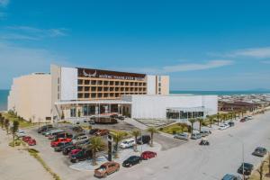 a hotel with cars parked in a parking lot at Mường Thanh Luxury Xuân Thành in Ha Tinh