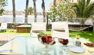 een glazen tafel met een fruitschaal erop bij Confortable independent Villa in San Agustin