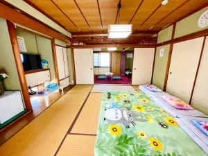Una habitación con una cama con flores. en 旅馆yo ko en Fuchisaki