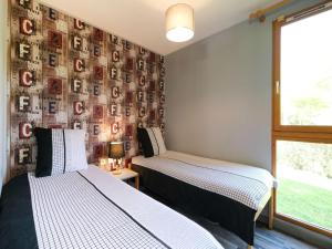 two beds in a room with a wall covered in photos at Comfortable holiday home with private terrace in Signy-le-Petit