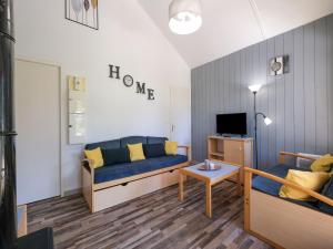 un salon avec un canapé bleu et une télévision dans l'établissement Comfortable holiday home with private terrace, à Signy-le-Petit