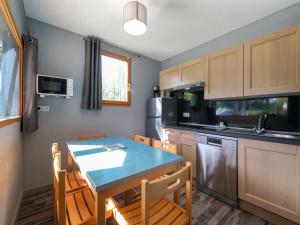 a kitchen with a blue table and chairs in it at Comfortable holiday home with private terrace in Signy-le-Petit