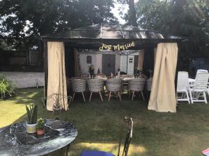 a gazebo with tables and chairs in a yard at Discoveries Guest House & luxury spa in Bournemouth