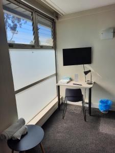 Zimmer mit Schreibtisch, Monitor und Stuhl in der Unterkunft Doonside Hotel in Doonside