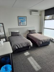 a bedroom with two beds and a table in it at Doonside Hotel in Doonside