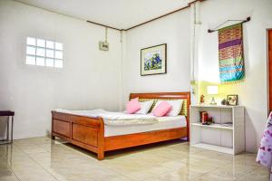 - une chambre avec un lit et des oreillers roses dans l'établissement Serenity1 Homestay, à Chiang Dao