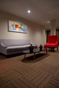 a living room with a couch and a red chair at News Hotel Waru Sidoarjo in Waru