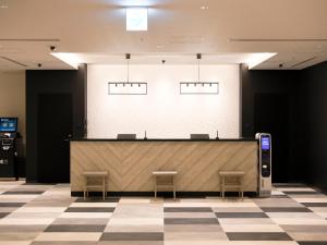 a lobby with a reception counter and two stools at Wakoshi Tobu Hotel in Wako