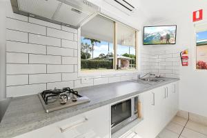 a white kitchen with a sink and a stove at Ingenia Holidays Noosa in Tewantin