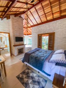 a bedroom with a large bed and a fireplace at Refúgio Physis Suítes in Monte Verde