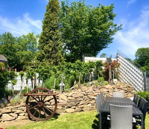 a garden with a stone wall and a wooden wheel at FRANKES LODGE Apartment mit Garten, 6 Einzelbetten, Parkplatz in Essen