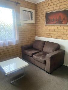 a living room with a couch and a coffee table at Aspley Pioneer Motel in Brisbane