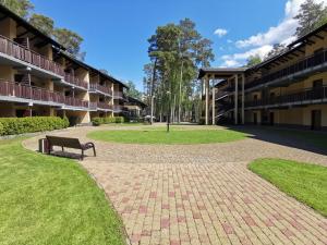 un parc avec un banc à côté d'un bâtiment dans l'établissement Sea&Forest Pogorzelica Apartament Perłowy, à Pogorzelica