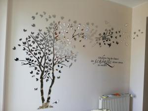 ein Baum mit Blättern und Vögeln an der Wand in der Unterkunft Haus Friedburg in Velden am Wörthersee