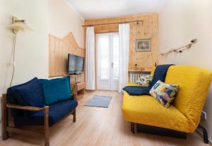 a living room with a yellow couch and a chair at Willa Zachęta in Krynica Zdrój