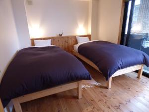 Postel nebo postele na pokoji v ubytování Guesthouse Hyakumanben Cross