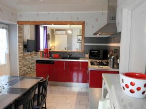 eine Küche mit roten Schränken und einer Arbeitsplatte in der Unterkunft Gîte Choiseul, 3 pièces, 4 personnes - FR-1-611-23 