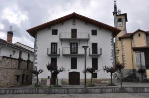 a white building with a clock tower on top at Apartamento Elizaldea in Betelu