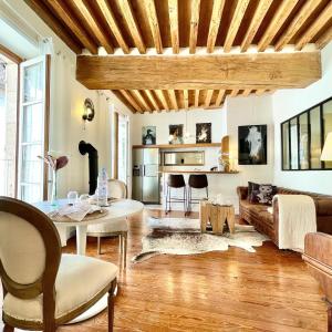 een woonkamer met een tafel en een bank bij Grand Cru, Appartement au Centre Médiéval de Beaune in Beaune