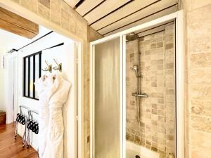 a bathroom with a shower and a robe hanging on a wall at Grand Cru, Appartement au Centre Médiéval de Beaune in Beaune