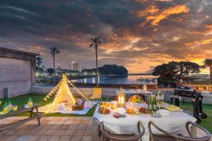 白濱的住宿－West Coast Villa Shirahama，露台上的一张桌子和一张帐篷,享有日落美景