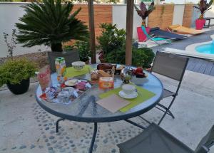 a glass table with food on it on a patio at La croix landolle in Châteaubernard