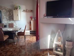 a living room with a table and a television on a wall at Apartment Alina in Umag
