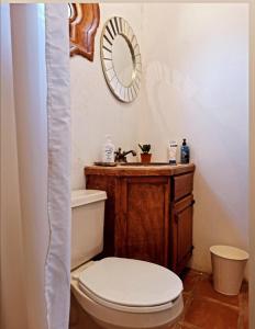 a bathroom with a toilet and a mirror at Large apartament near the beach in Rosarito
