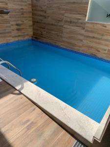 una gran piscina azul con suelo de madera en Ótimo Apartamento no coração da Ponta Verde, en Maceió