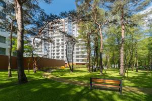um parque com um banco em frente a um edifício em Apartamenty Baltica Towers Modern White&Black em Gdansk